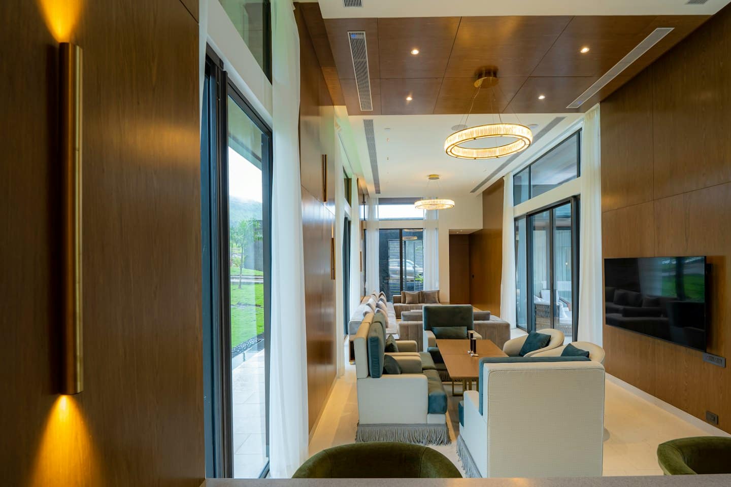 Modern lounge area with contemporary furniture and large windows overlooking hills.
