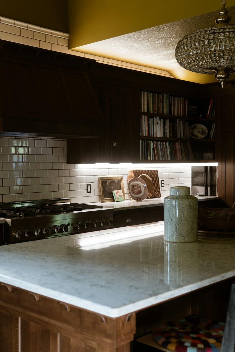 Modern kitchen with dark wooden cabinets and a marble island.